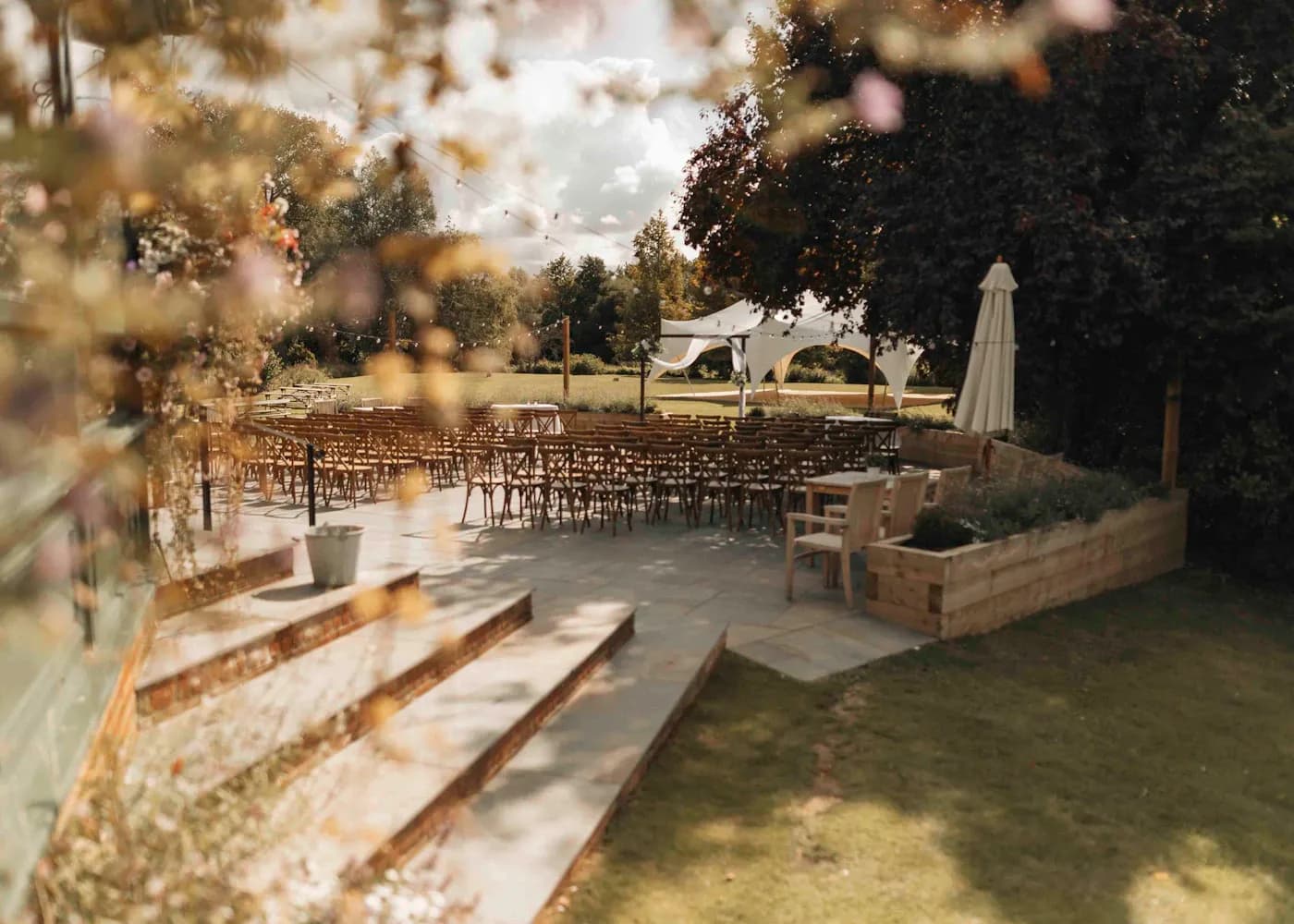 Chairs set under trees for a small garden wedding ceremony